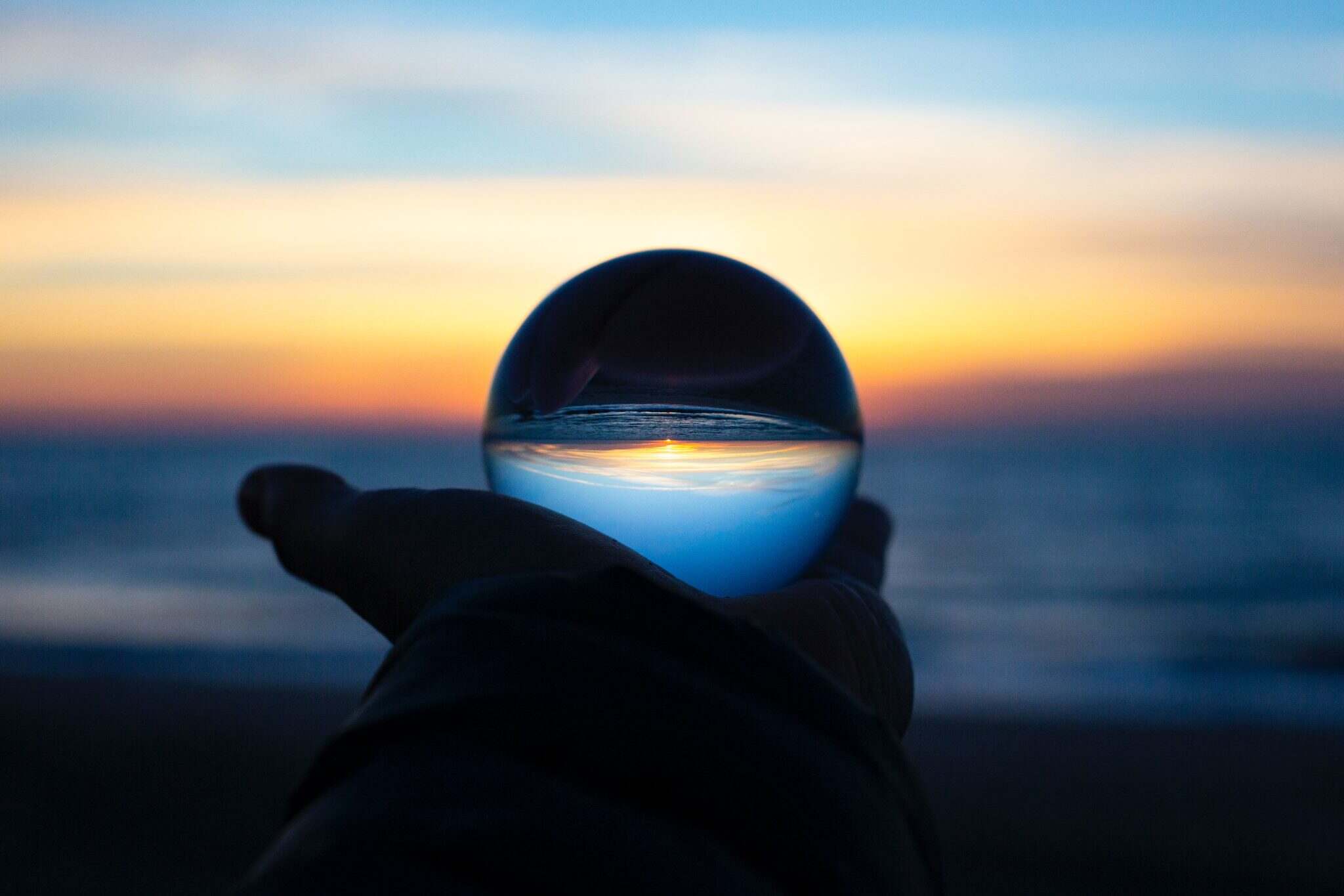 hand holding ball on sunset