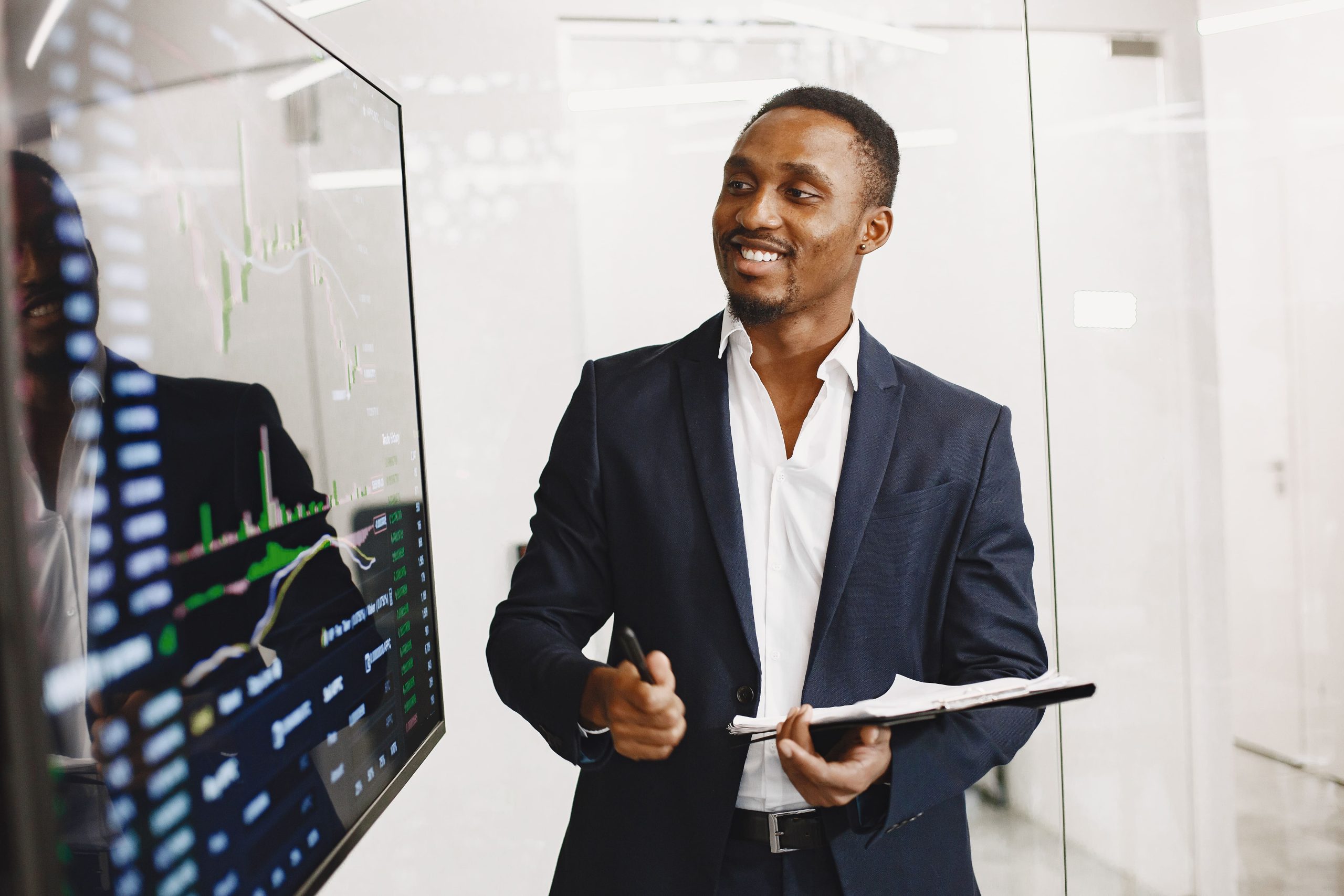 a smiling businessman stands in front of an interactive whiteboard and explains the material