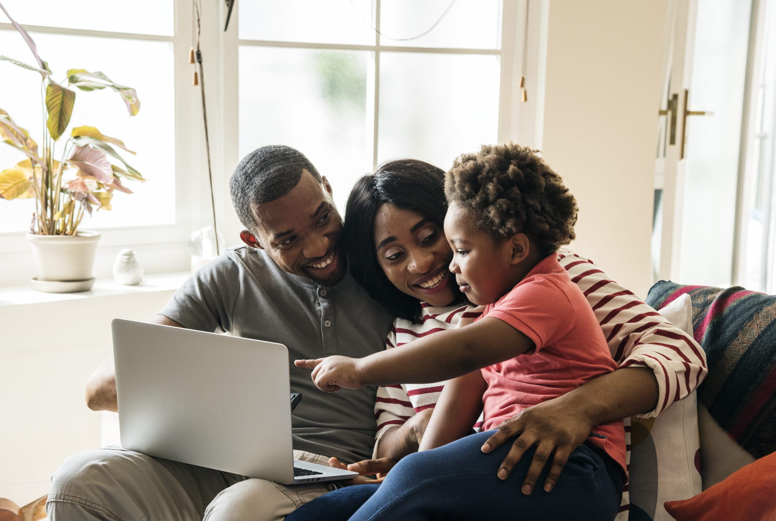 happy family sitting in the living room and looking at the computer